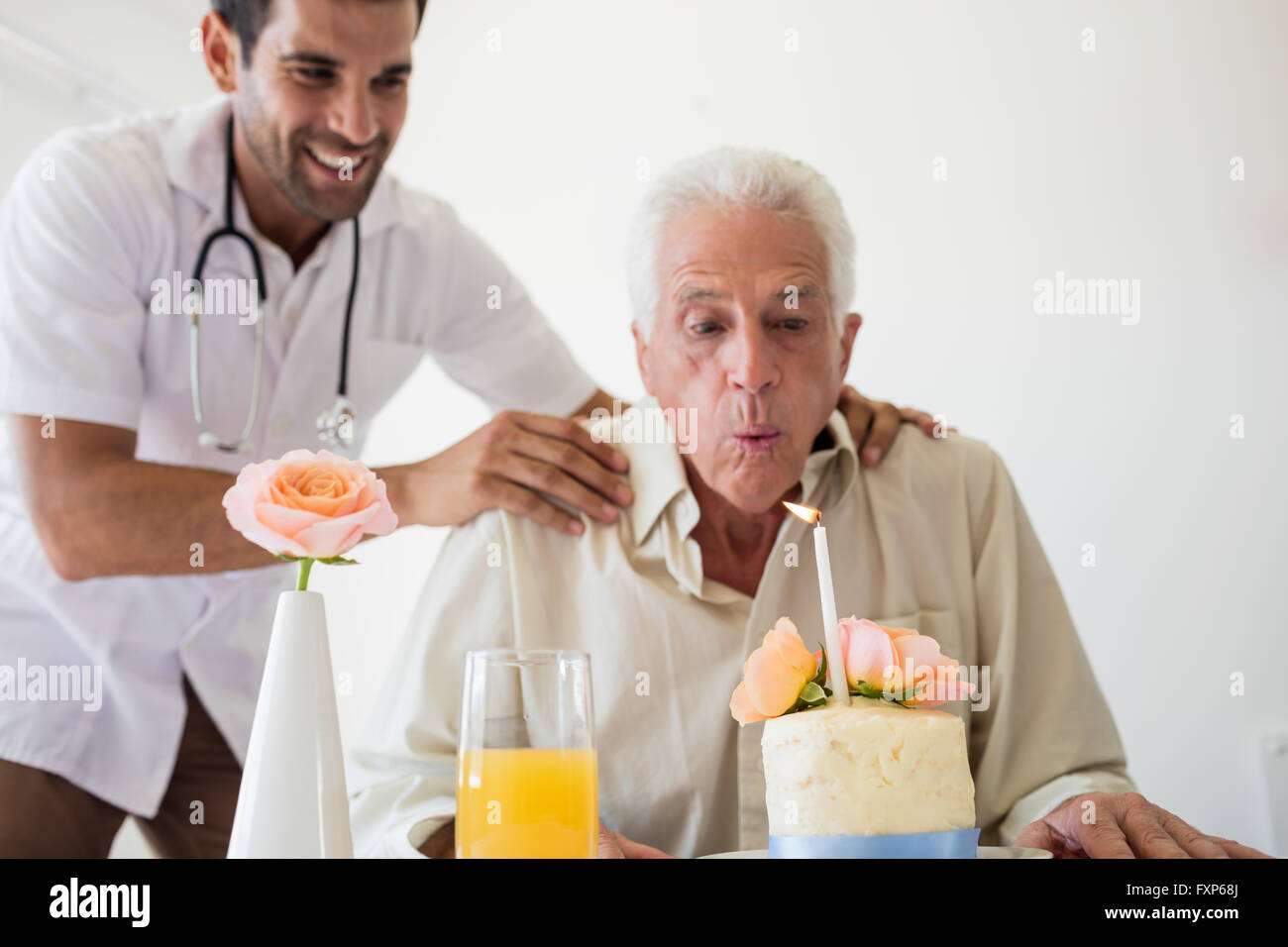 Ältere Mann feiert seinen Geburtstag mit einer Torte Stockfoto