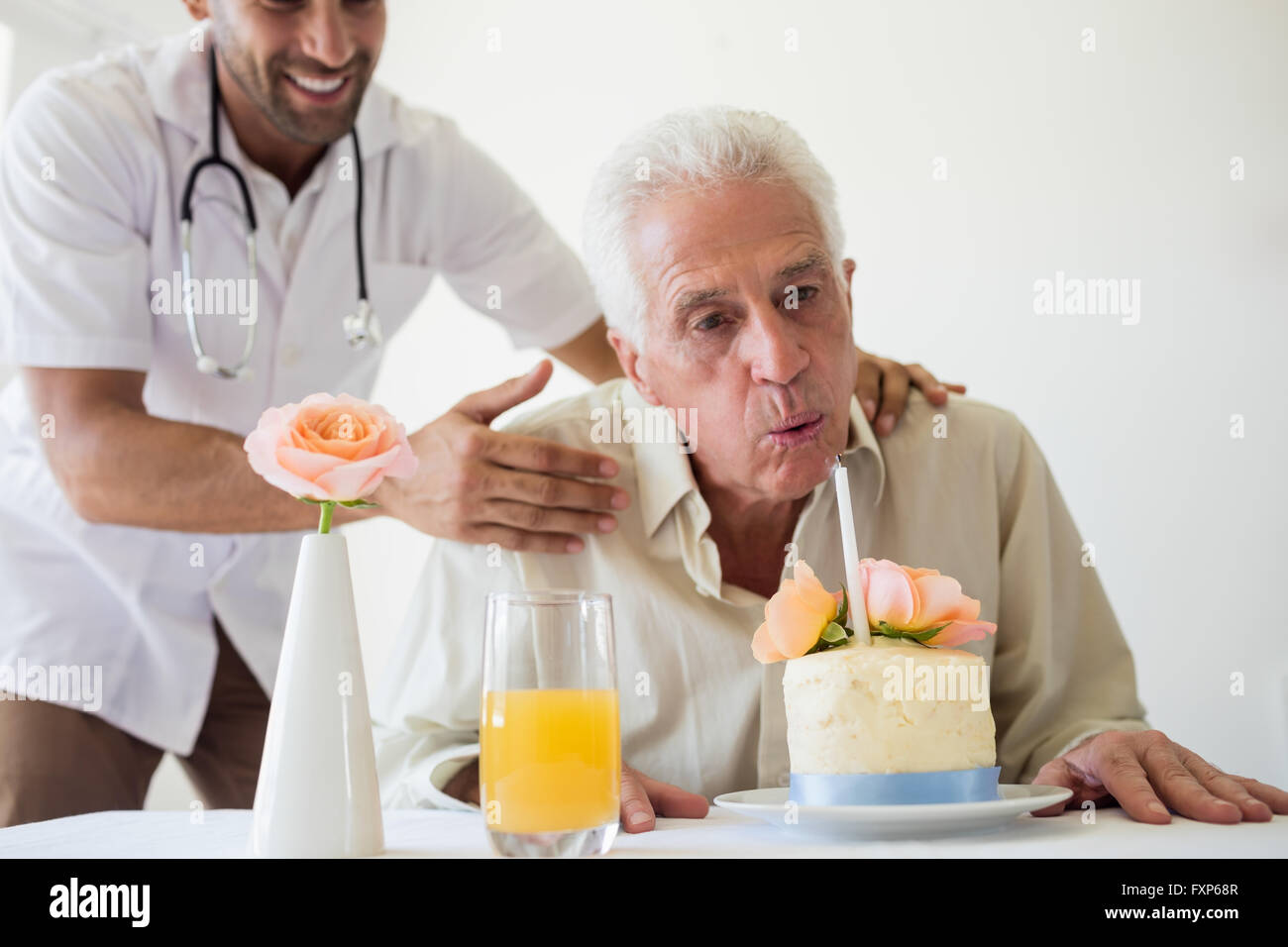 Ältere Mann feiert seinen Geburtstag mit einer Torte Stockfoto