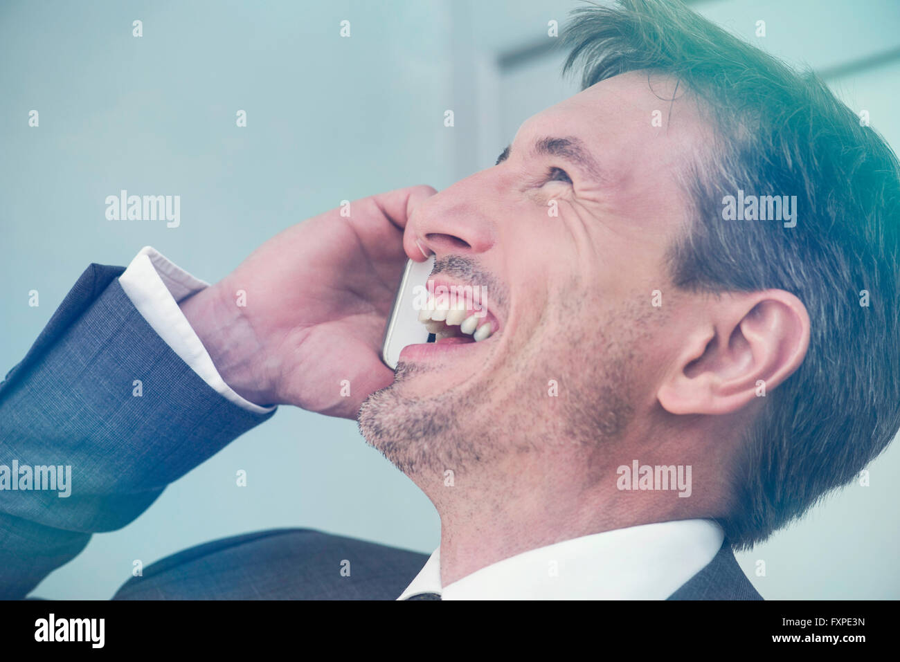 Mann lachend auf Handy Stockfoto