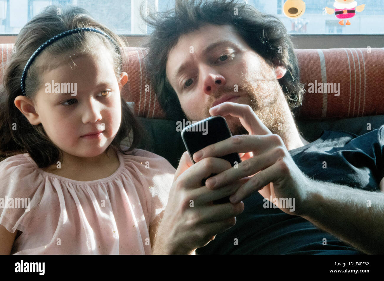 Vater und junge Tochter Smartphone zusammen betrachten Stockfoto