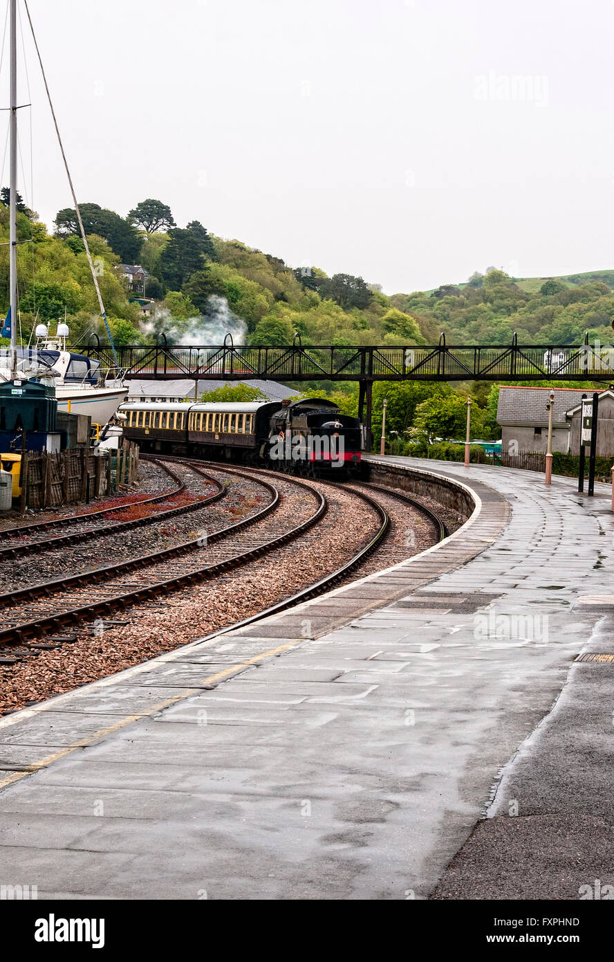 Die restaurierten Personenzug Lydham Manor glänzt, wie es Trainer in einer Kurve neben der Plattform Kingswear Station schleppt Stockfoto