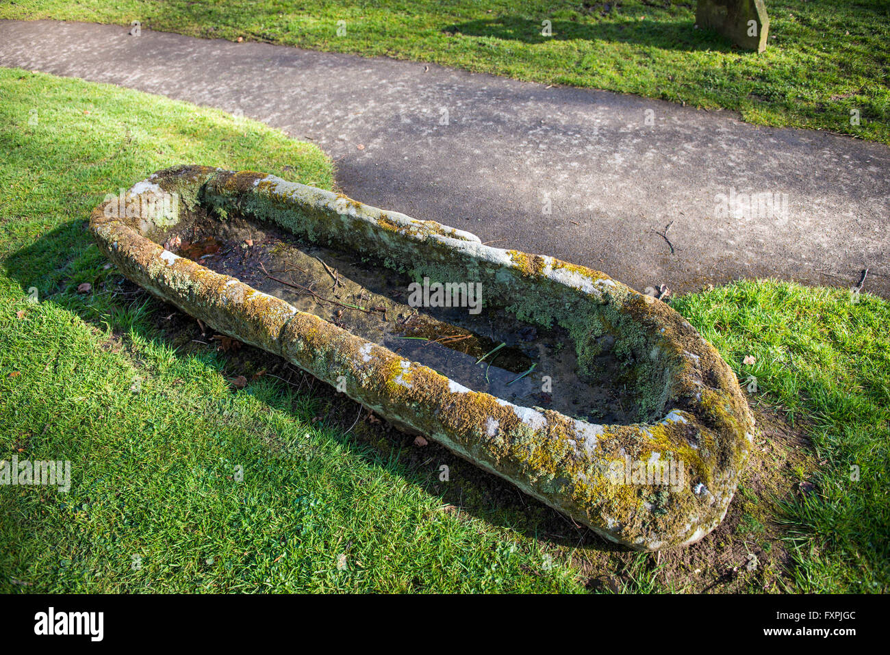 Eine solide Steinsarg auf dem Friedhof der St.-Petri Kirche mit Blick auf Morecambe Bay in Heysham, Lancashire, UK Stockfoto