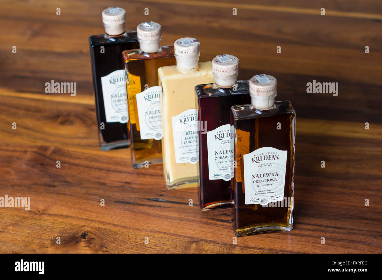 Flaschen von verschiedenen polnischen Liköre produziert von Krakowski Kredens, präsentiert auf einem Holztisch. Geringe Schärfentiefe. Stockfoto