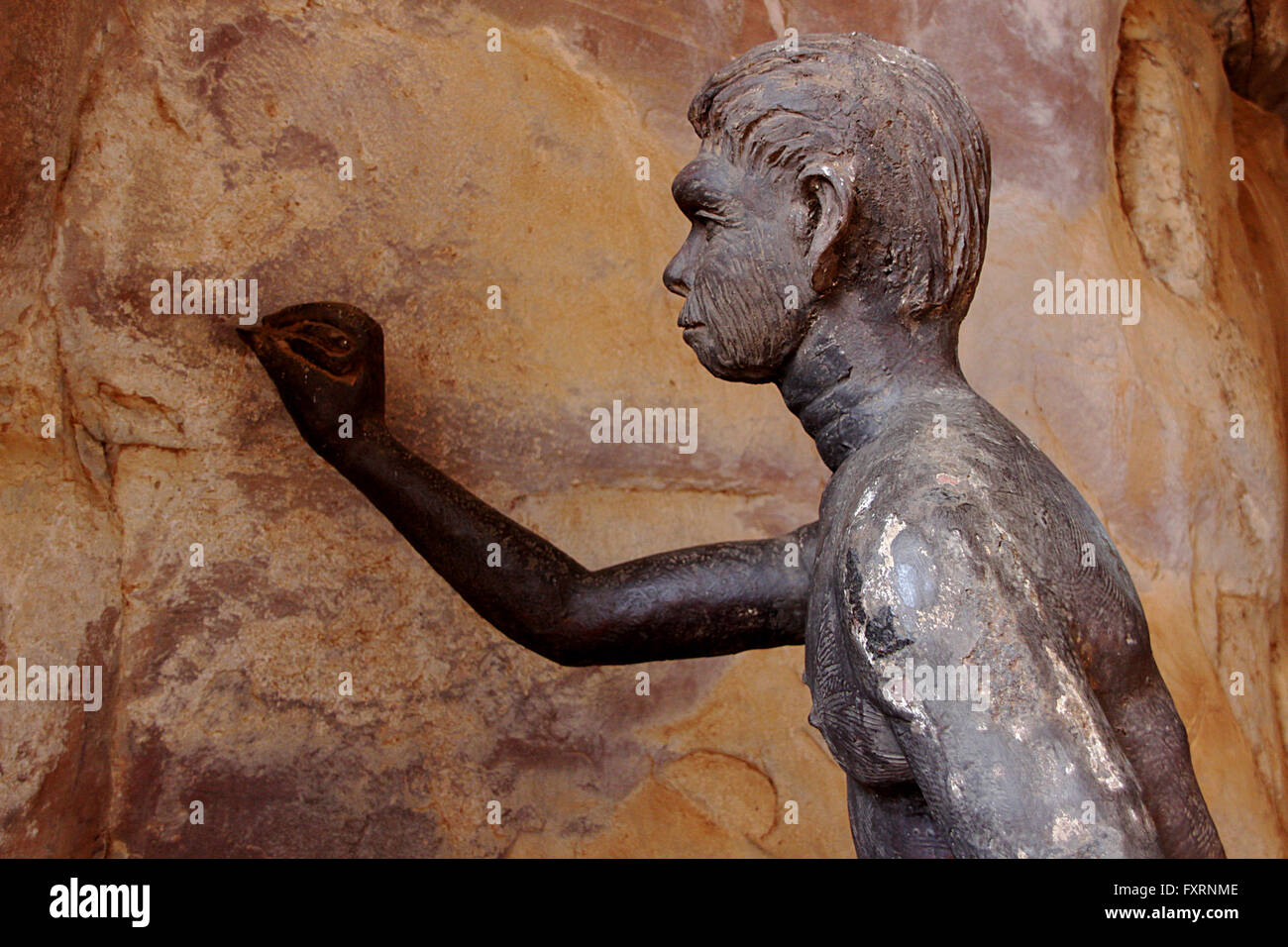 Prähistorischen Menschen, die versuchen, Skizzen auf Wand von seinem Abri an Bhimbetka, in der Nähe von Bhopal, Madhya Pradesh, Indien, Asien Stockfoto