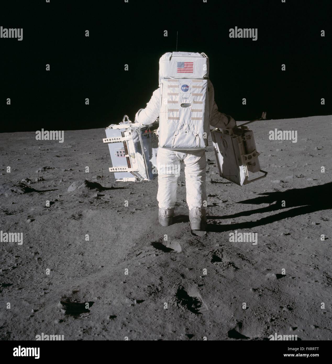 NASA Astronaut und Mondlandefähre pilot Buzz Aldrin Spaziergänge Bestandteile der frühen Apollo wissenschaftlichen Experimenten auf der Oberfläche des Mondes während der Apollo 11 Extravehicular Tätigkeit 20. Juli 1969 im Meer der Ruhe, Mond bereitstellen. Stockfoto