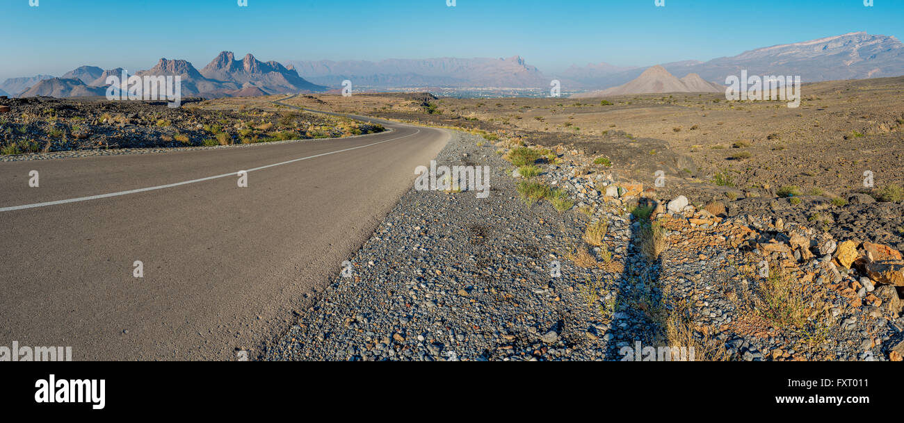 Autobahn durch raue Wildnis im Al Hajar-Gebirge, Oman. Stockfoto