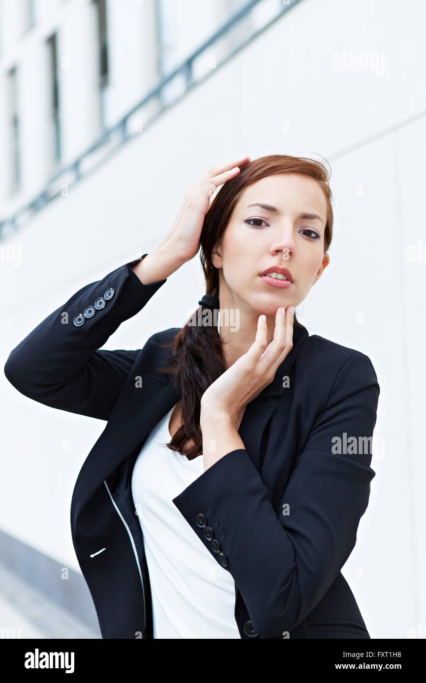 Attraktive Geschäftsfrau, die ihr Gesicht mit den Händen berühren Stockfoto