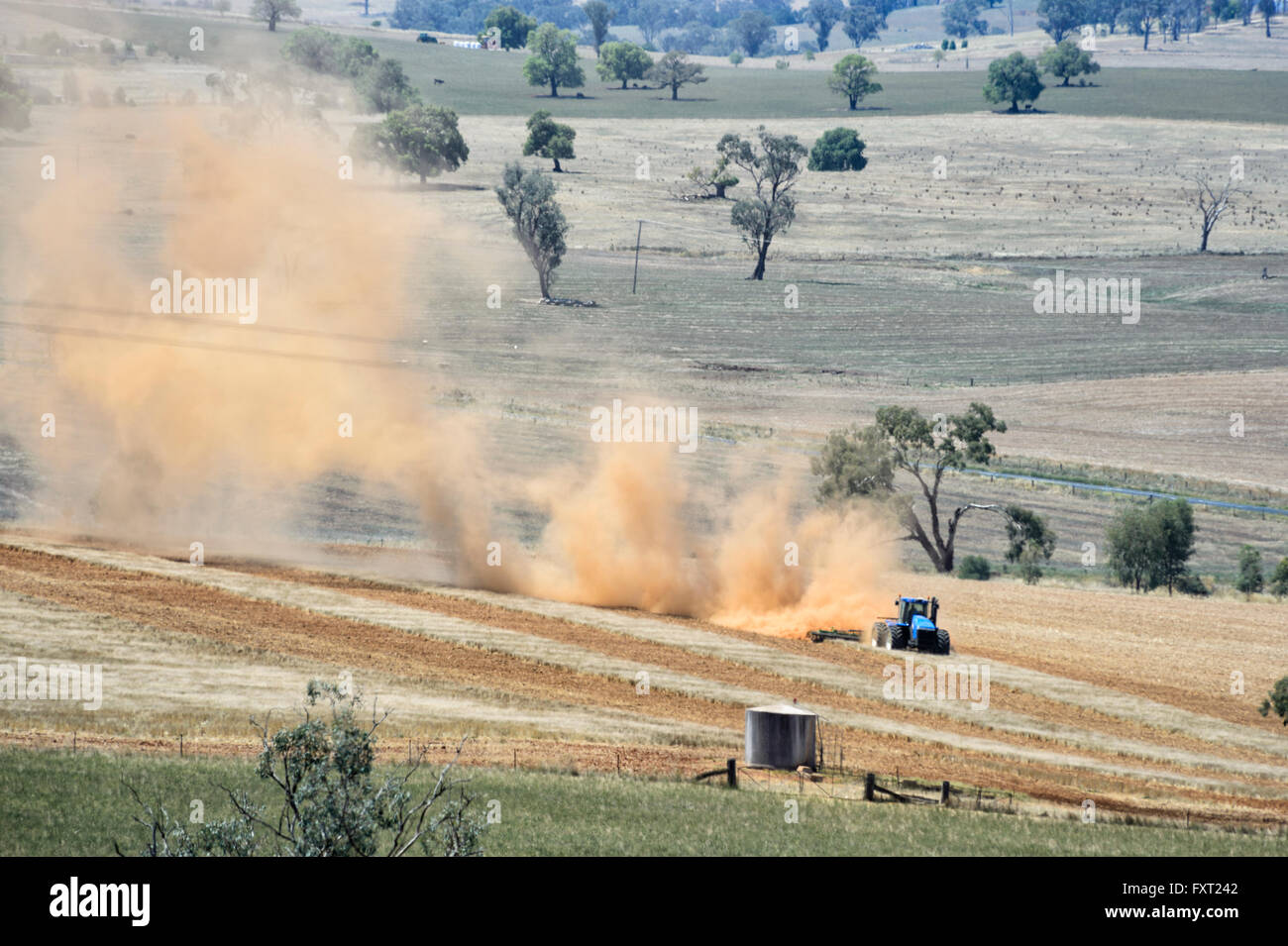 Traktor in einem Feld mit Staub fliegen, Fleurieu Peninsula, South Australia Stockfoto