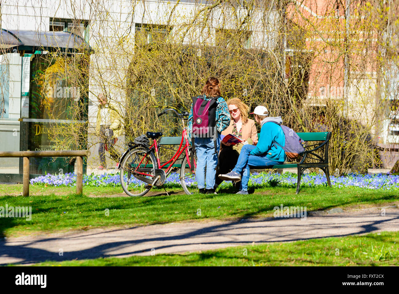 Lund, Schweden - 11. April 2016: Alltag in der Stadt. Junge Leute reden und diskutieren auf einer Bank in einem der Parks in der Stadt. Stockfoto
