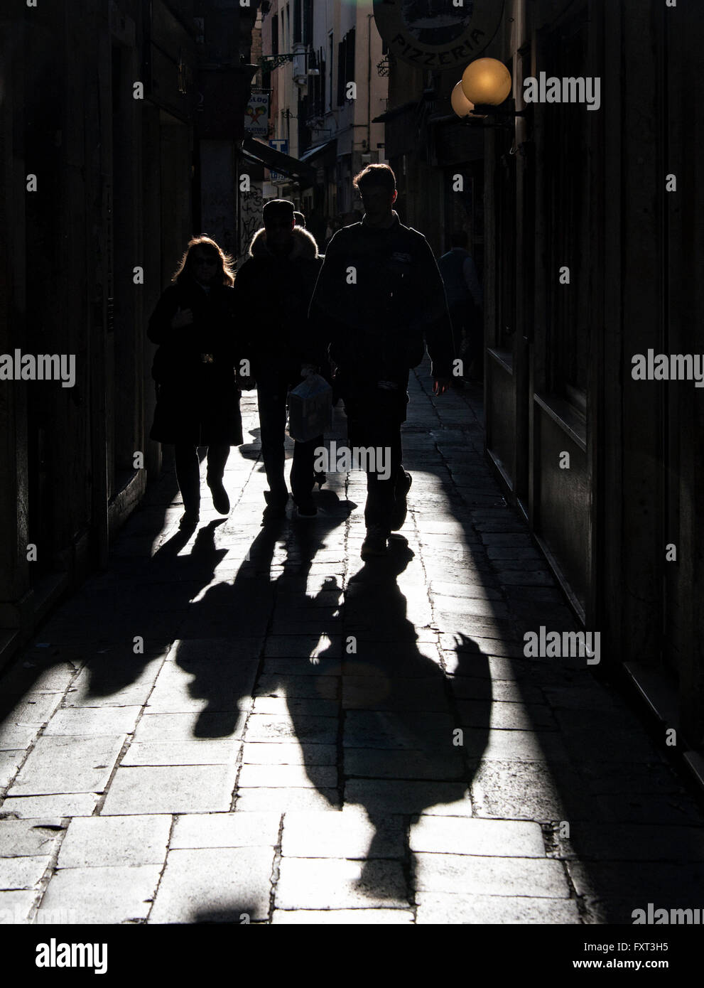 Fußgänger und ihre Schatten in einer Gasse, Gegenlicht, Venedig, Veneto, Italien Stockfoto
