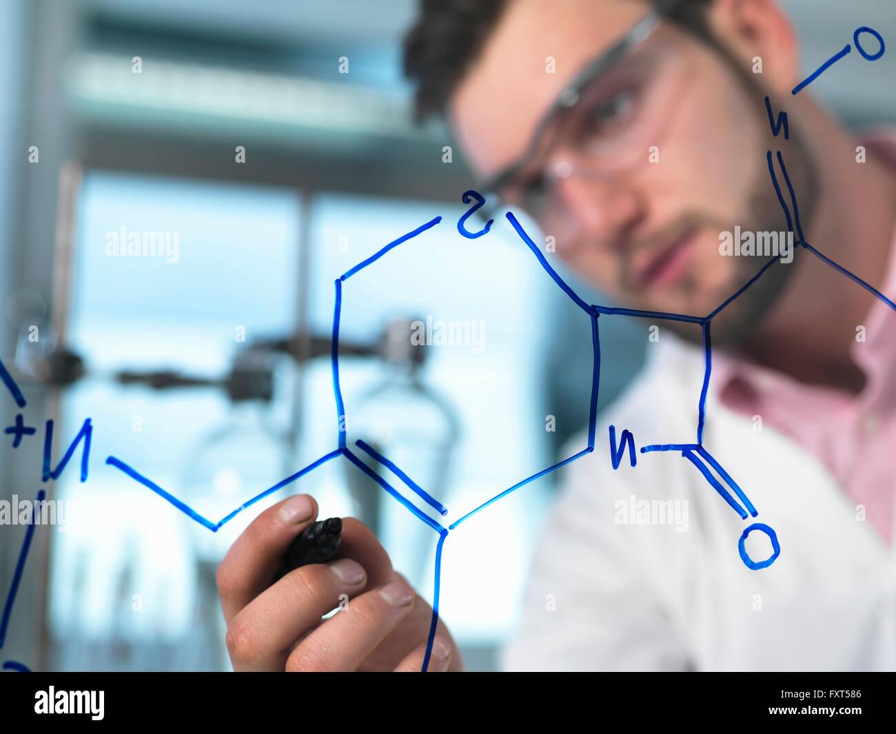 Junge männliche Wissenschaftler illustrieren Antibiotika chemische Formel in pharmazeutischen Forschungslabor Stockfoto