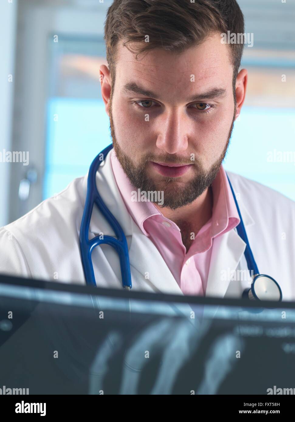 Junge männliche Junioren Arzt Röntgen der gebrochenen Hand im Krankenhaus untersuchen Stockfoto