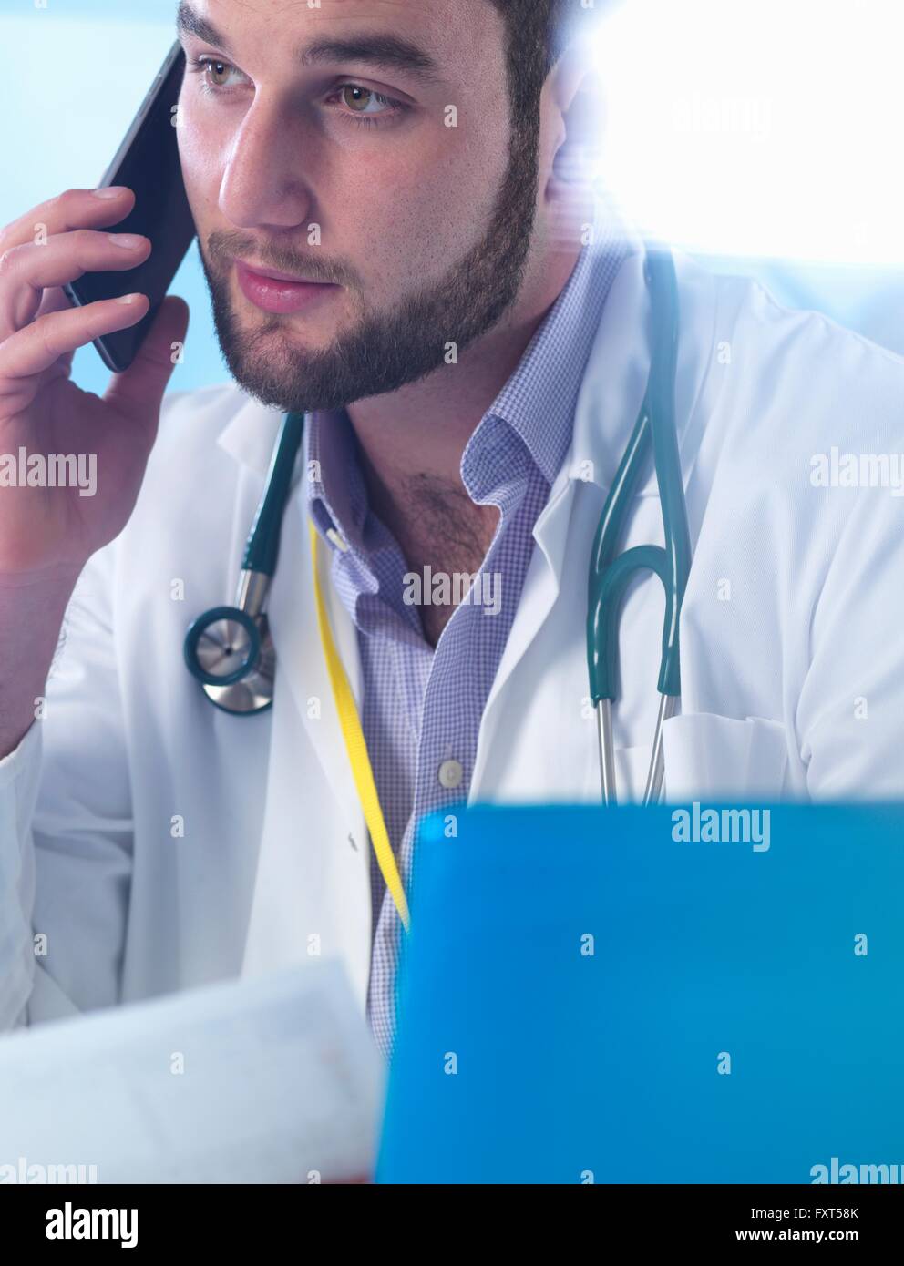 Junior Arzt mit Smartphone in Klinik Stockfoto