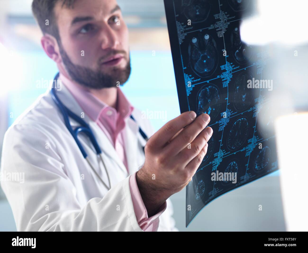 Junior Arzt untersuchen einen Gehirn-Scan im Krankenhaus Stockfoto