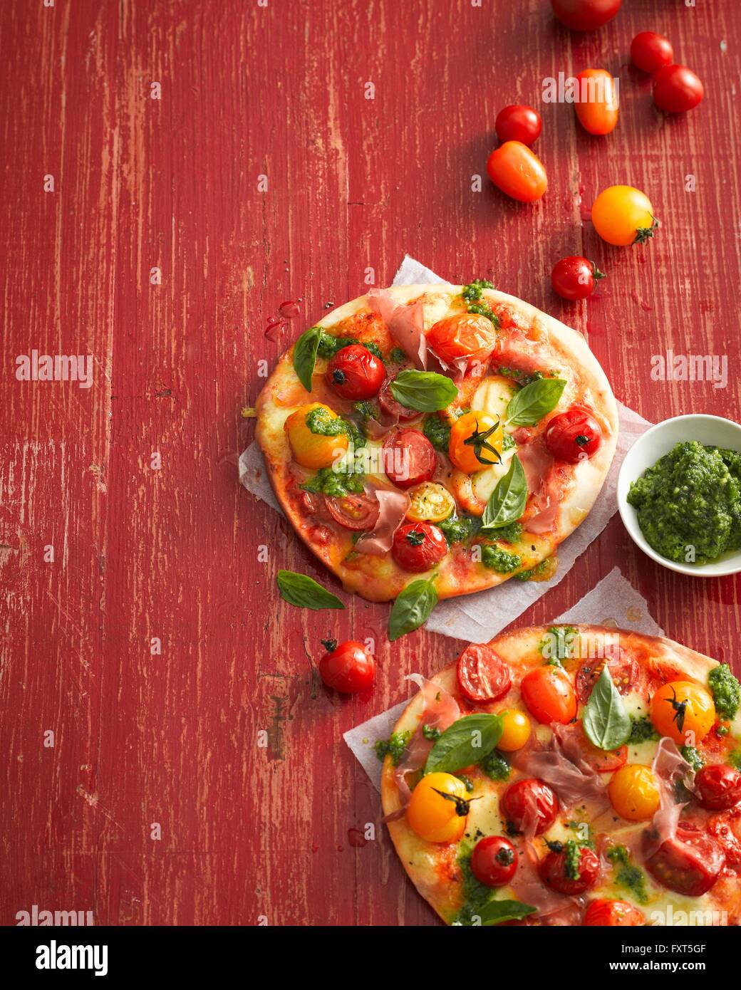 Vogelperspektive Blick auf Tomaten, Basilikum und Schinken Pizza Stockfoto