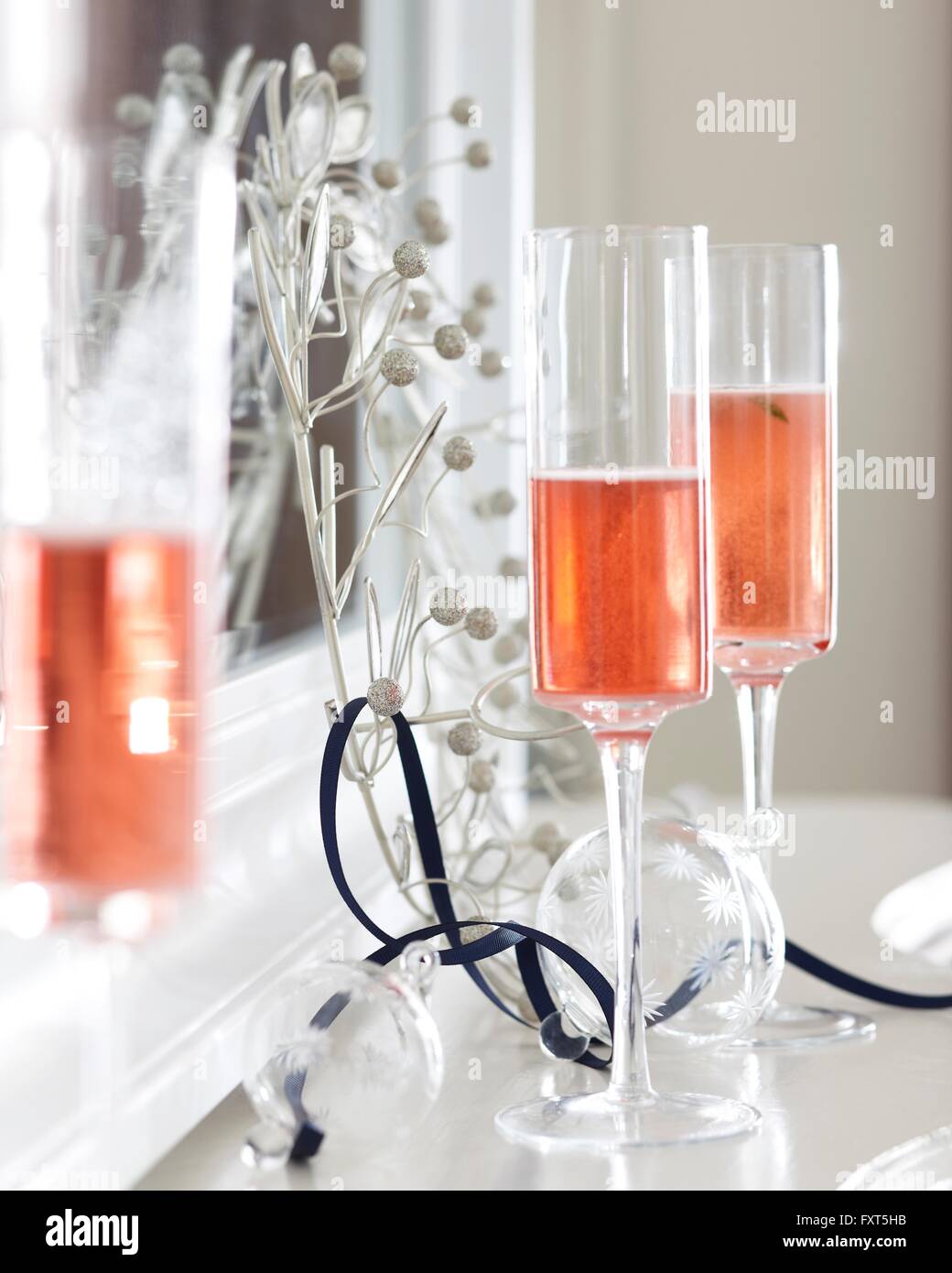 Sektgläser Champagner auf Kaminsims mit Weihnachtsschmuck Stockfoto