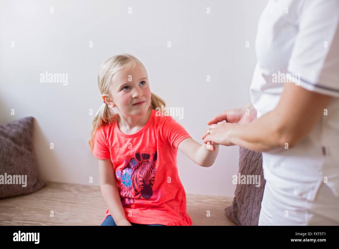 Mädchen sitzen halten Krankenschwestern Hand nur ungern nachschlagen Stockfoto