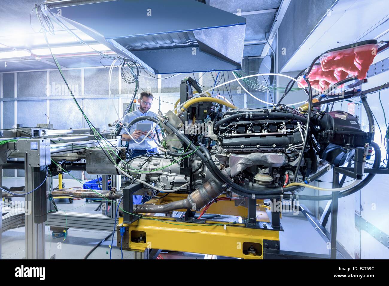 Ingenieur mit Automotor in der Bucht von Automobilteilen Fabrik Prüfung Stockfoto