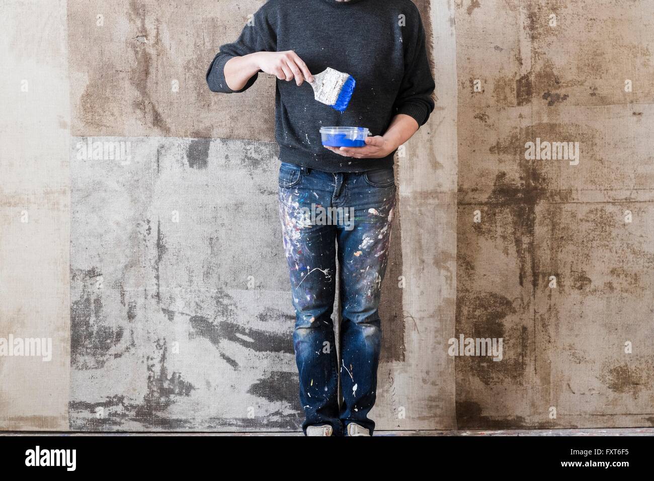 Mann hält Pinsel in der hand über Kunststoff-container Stockfoto