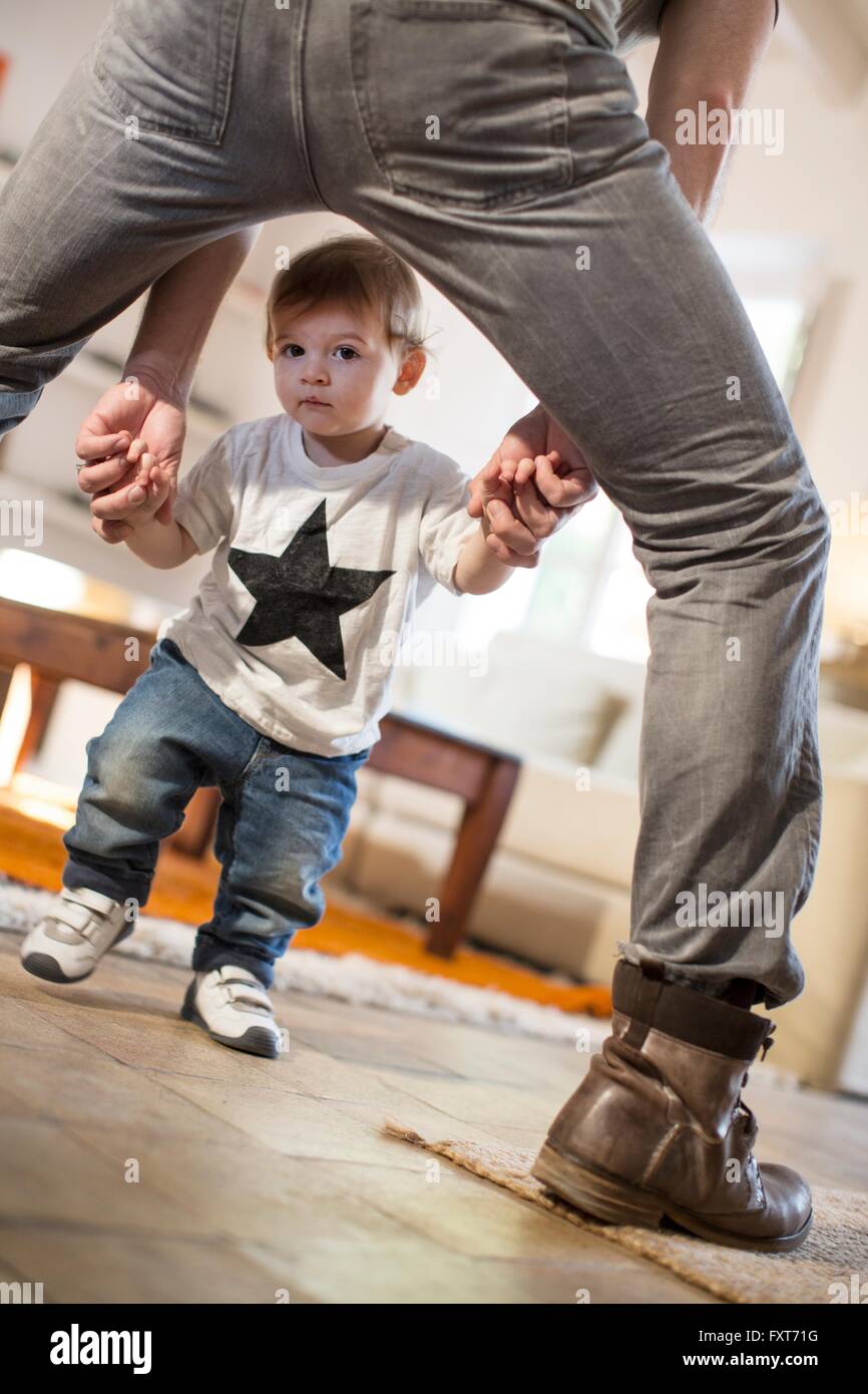 Blick durch Väter Beine Baby jungen Blick in die Kamera Stockfoto