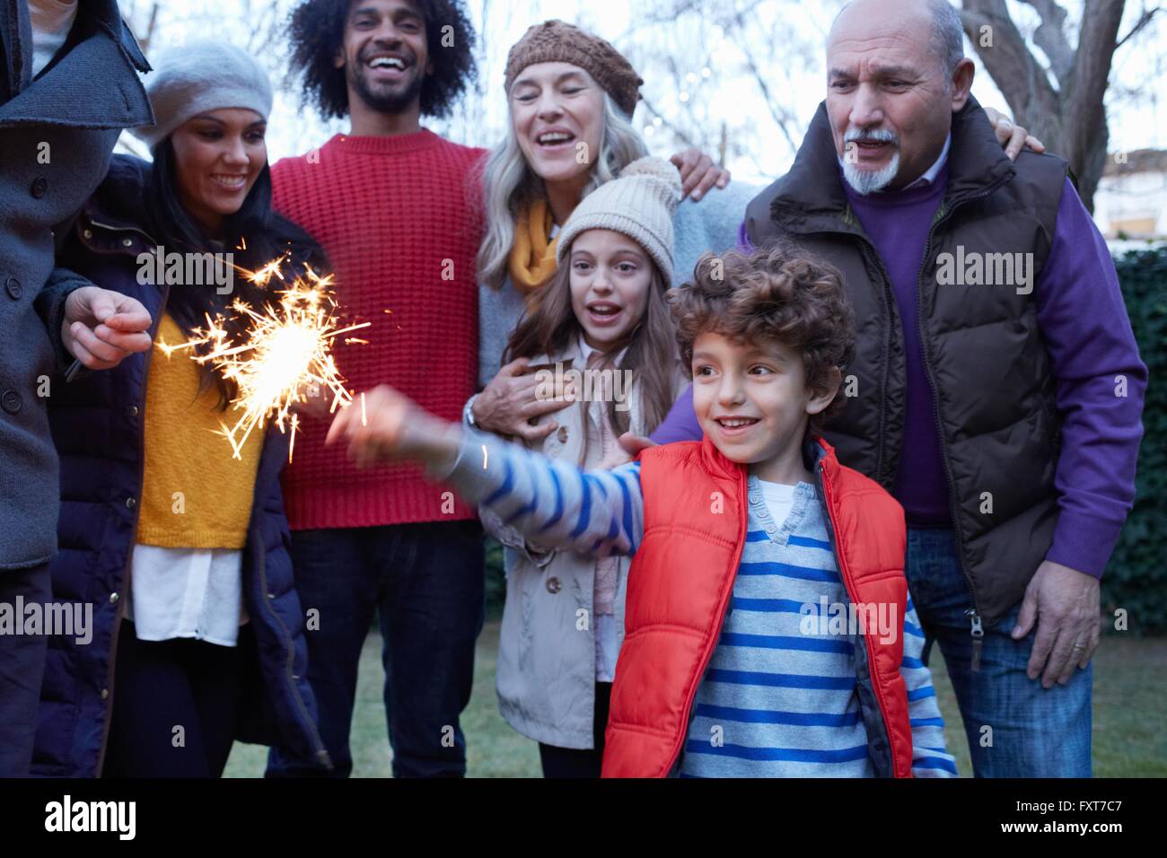 Junge mit Multi-Generationen-Familie hält lächelnd Wunderkerze Stockfoto