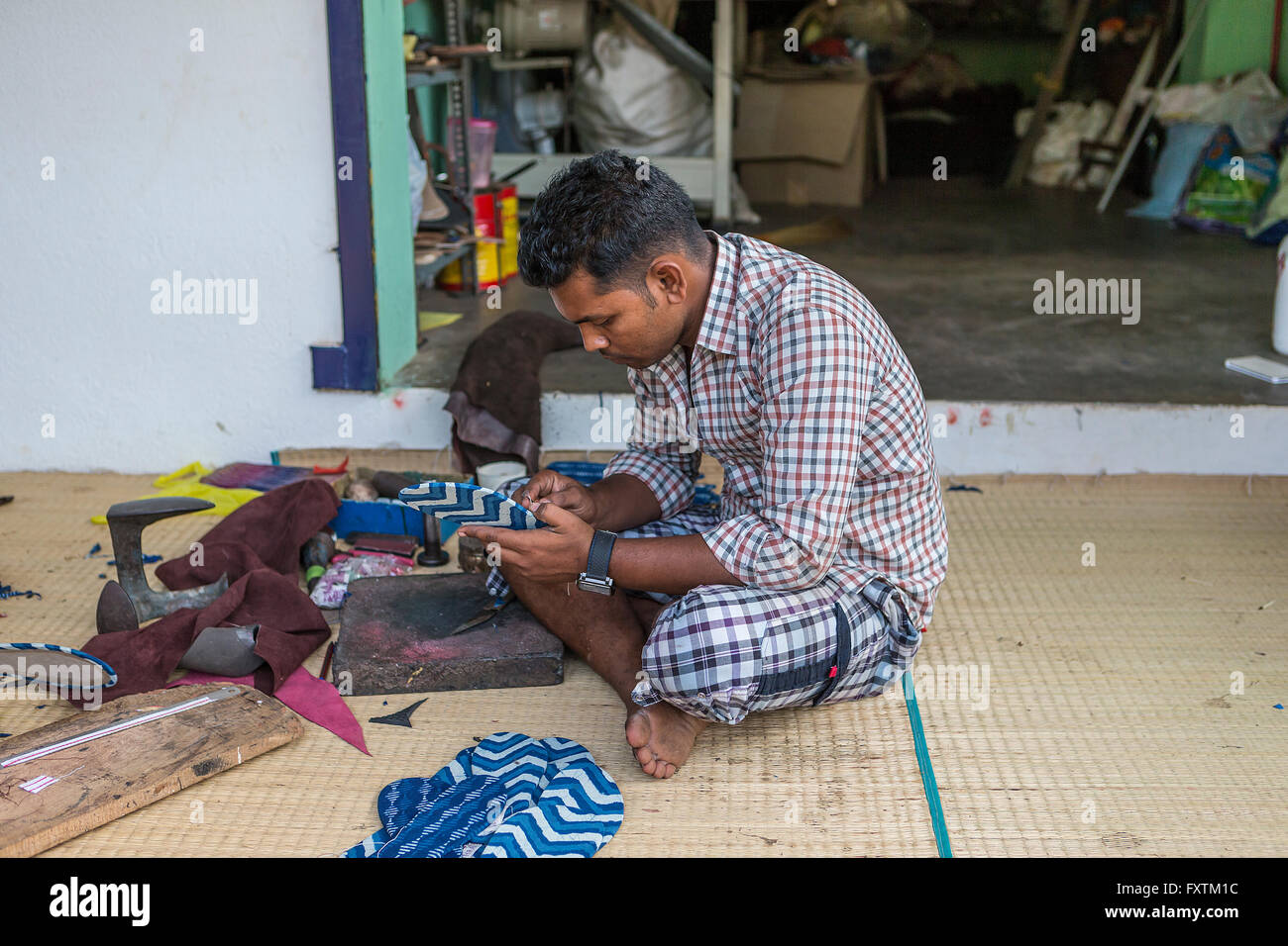 Inder Herstellung von Schuhen in einer provisorischen Werkstatt an der Seite der Straße in Kuilapalayam, Auroville, Indien Stockfoto