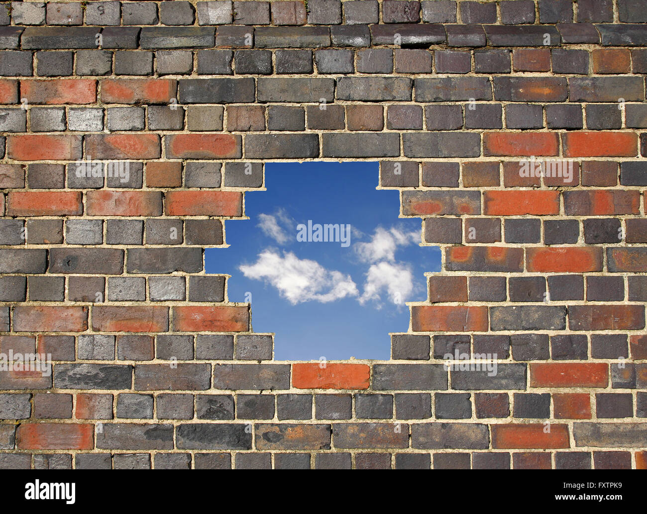 Blauer Himmel durch ein Loch in einer Mauer Stockfoto