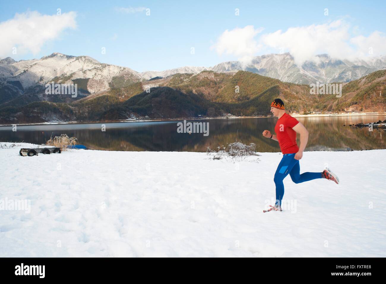 Männliche Läufer entlang Schnee bedeckt am See, Lake Kawaguchiko, Mount Fuji, Japan Stockfoto