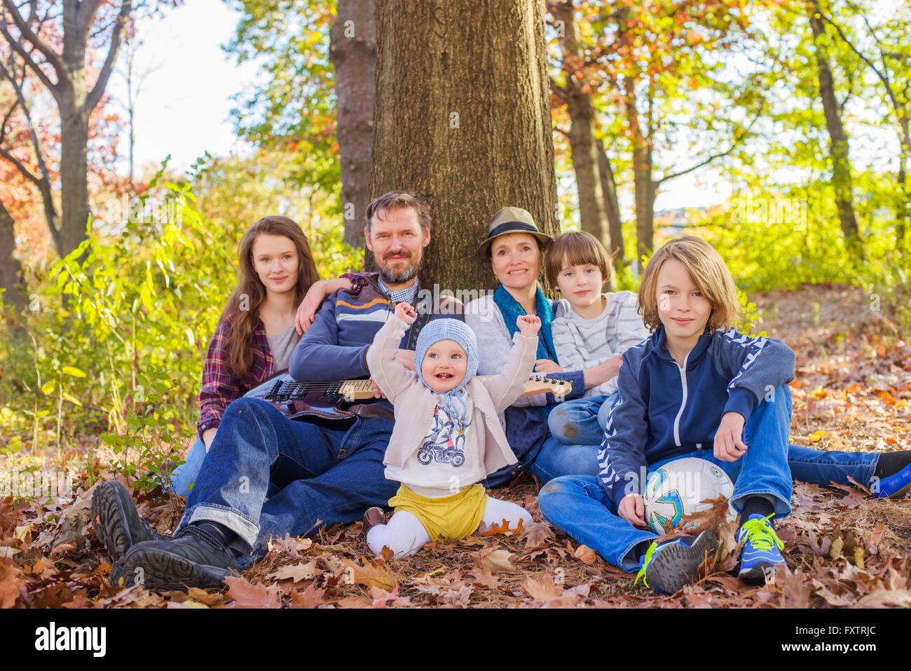 Porträt der Familie sitzen im Wald, Baum Stockfoto