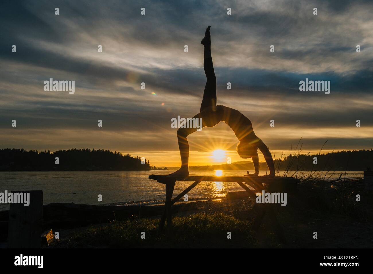 Frau praktizieren Yoga See bei Sonnenuntergang Stockfoto