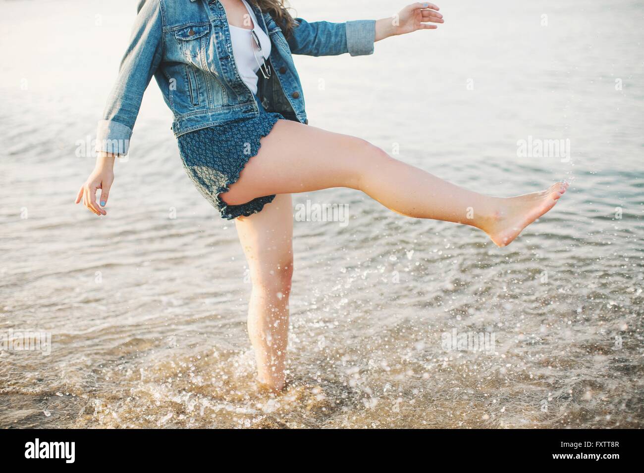 Niedrigen Bereich Seitenansicht der Frau auf einem Bein, Paddeln im Ozean Stockfoto