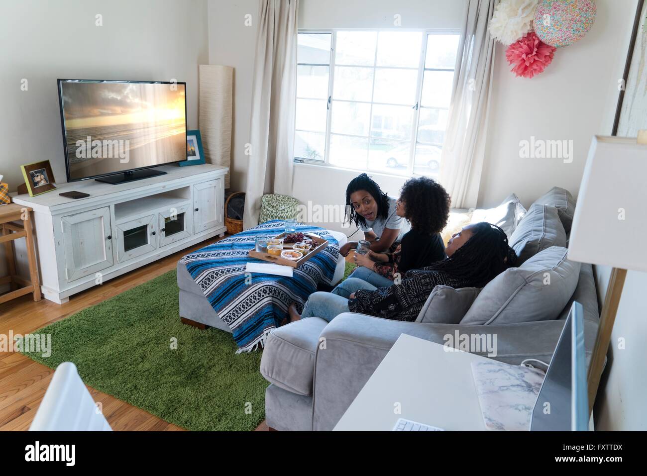 Drei Freundinnen zu Hause entspannen, Fernsehen Stockfoto