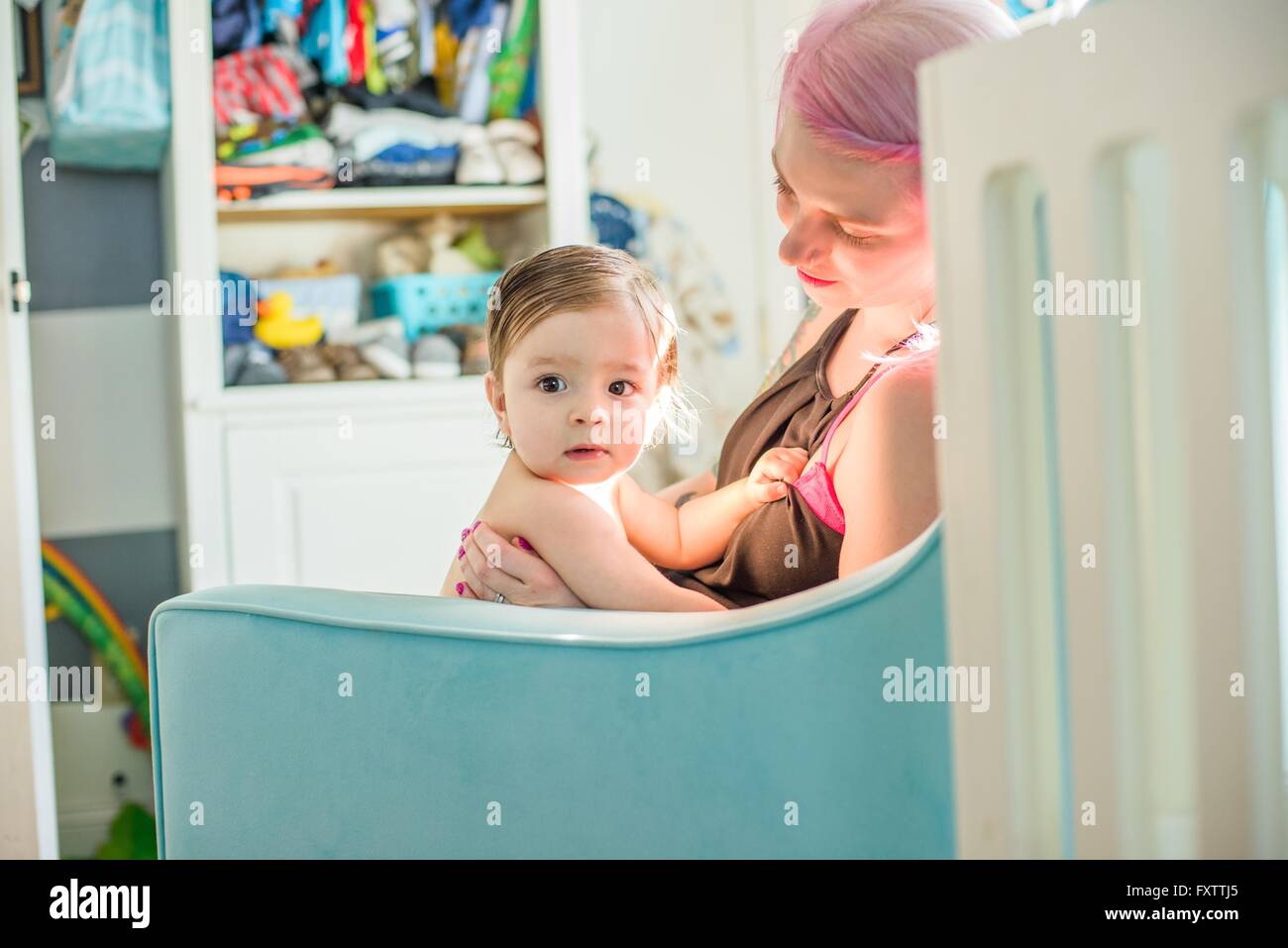 Mutter mit Baby Sohn auf Kinderzimmer Sofa sitzen Stockfoto