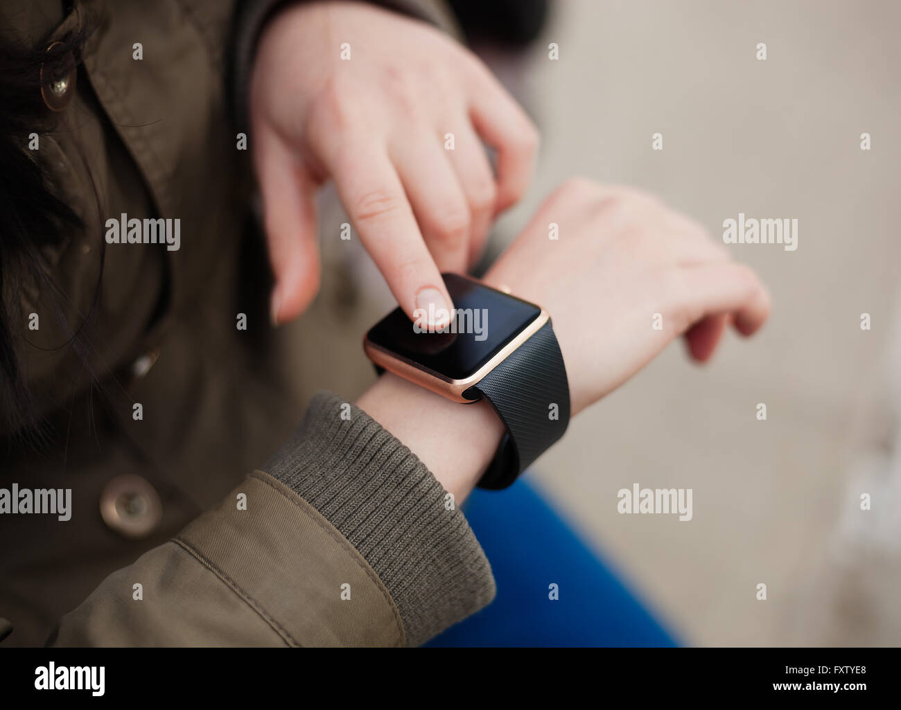 Hände einer Frau mit ihrem trendigen intelligente Armbanduhr. Das neue Gadget können Sie immer mit Internet und social Media Netzwerke von überall bleiben Sie, was Sie wollen. Stockfoto