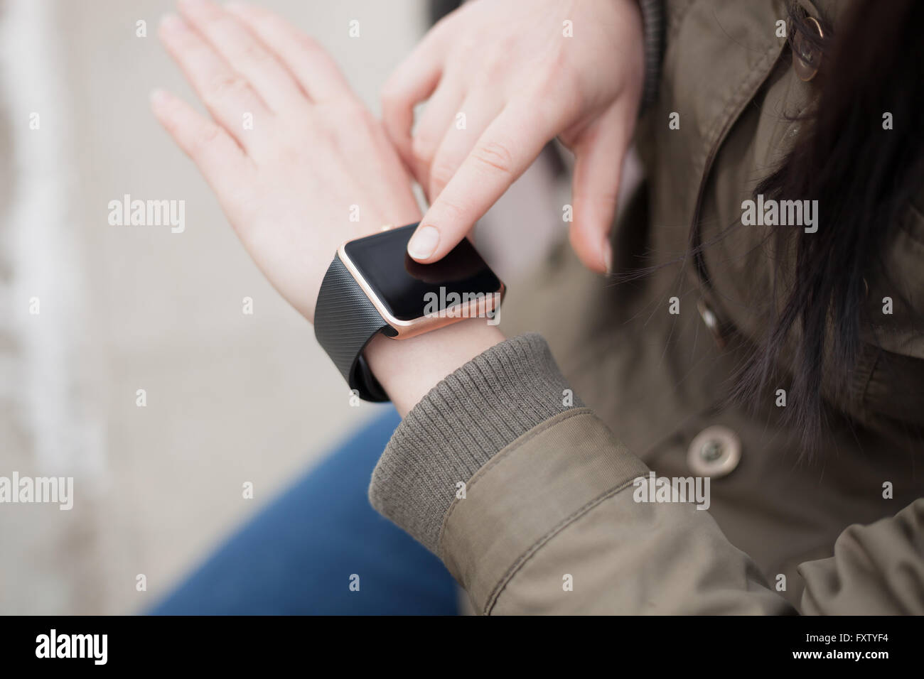 Hände eines Mädchens mit ihrem trendigen intelligente Armbanduhr. Das neue Gadget können Sie immer mit Internet und social Media Netzwerke von überall bleiben Sie, was Sie wollen. Stockfoto