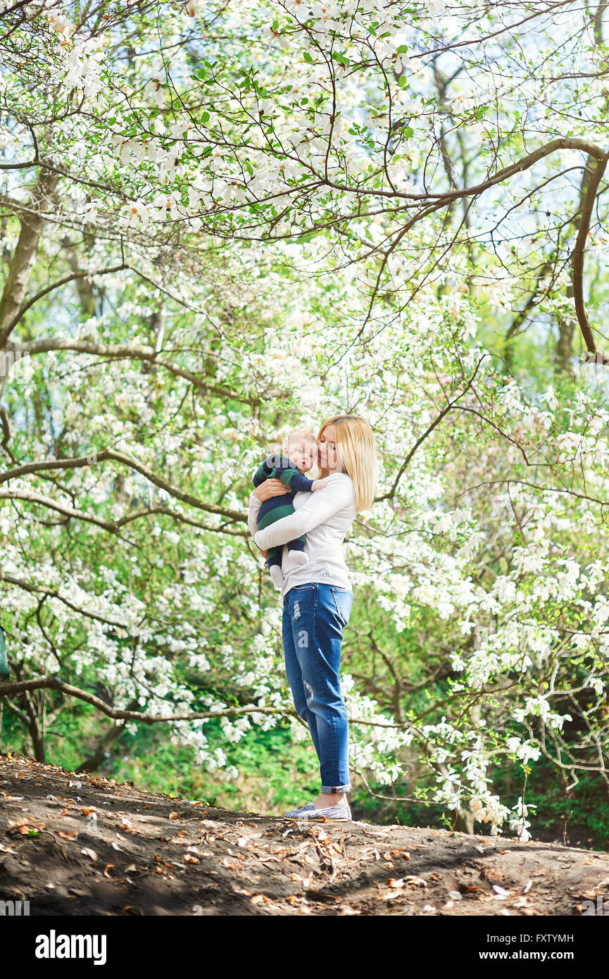 Kleinen Jungen mit der jungen Mutter im blühenden Frühlingsgarten Stockfoto