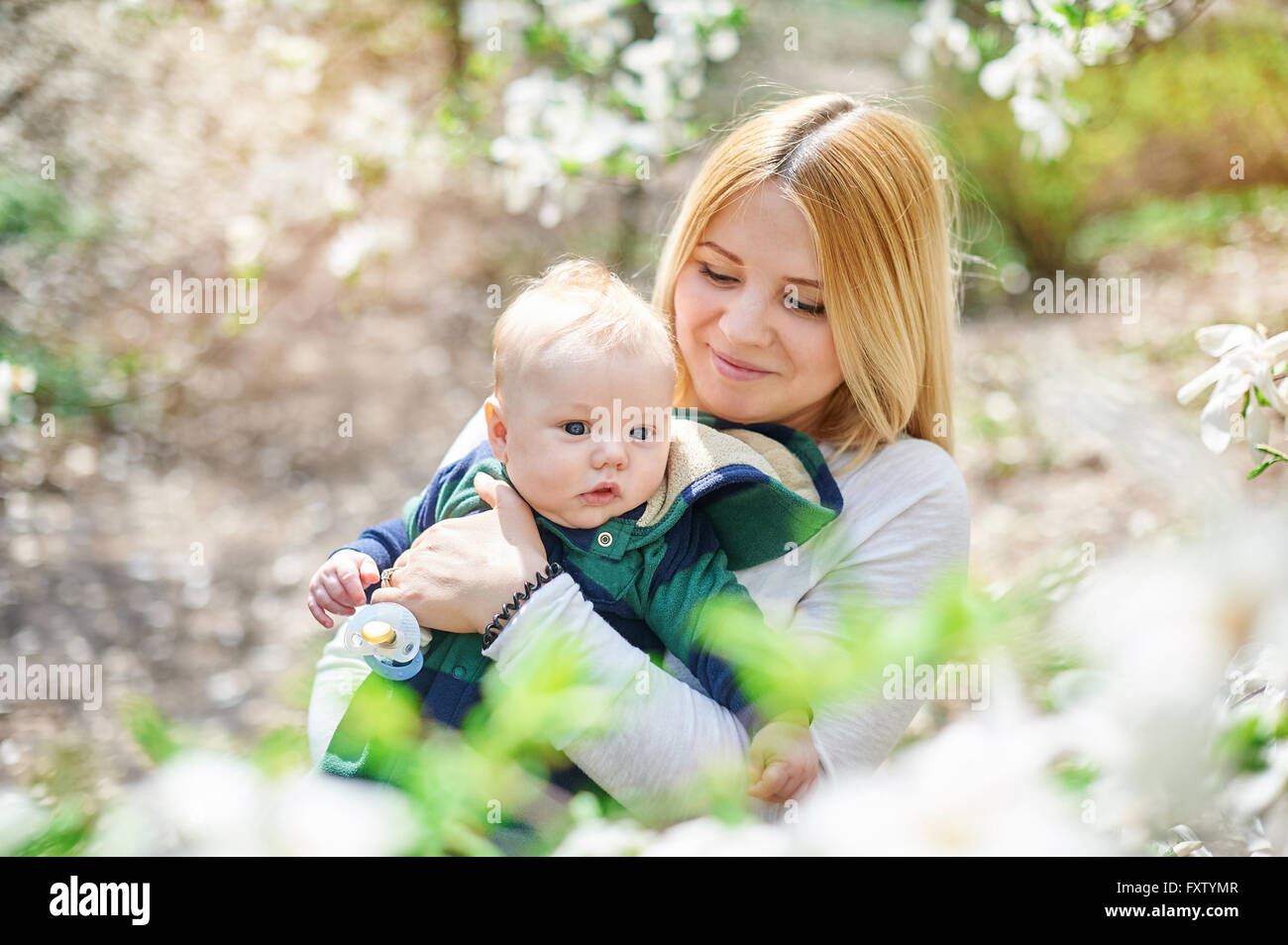Kleinen Jungen mit der jungen Mutter im blühenden Frühlingsgarten Stockfoto