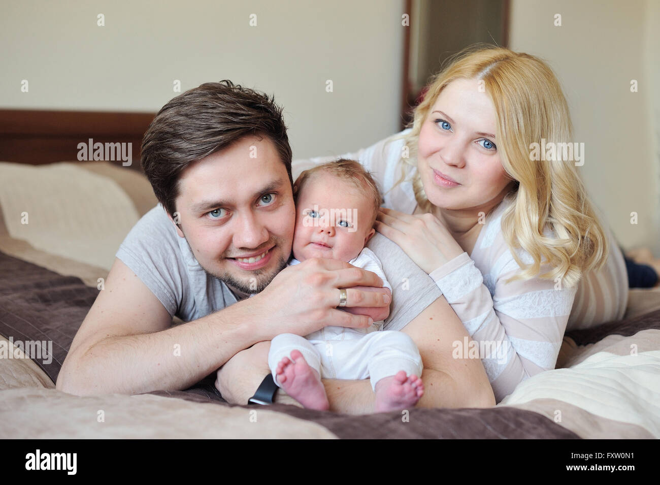 Glückliche junge attraktive Familie Eltern mit Neugeborenen Stockfoto