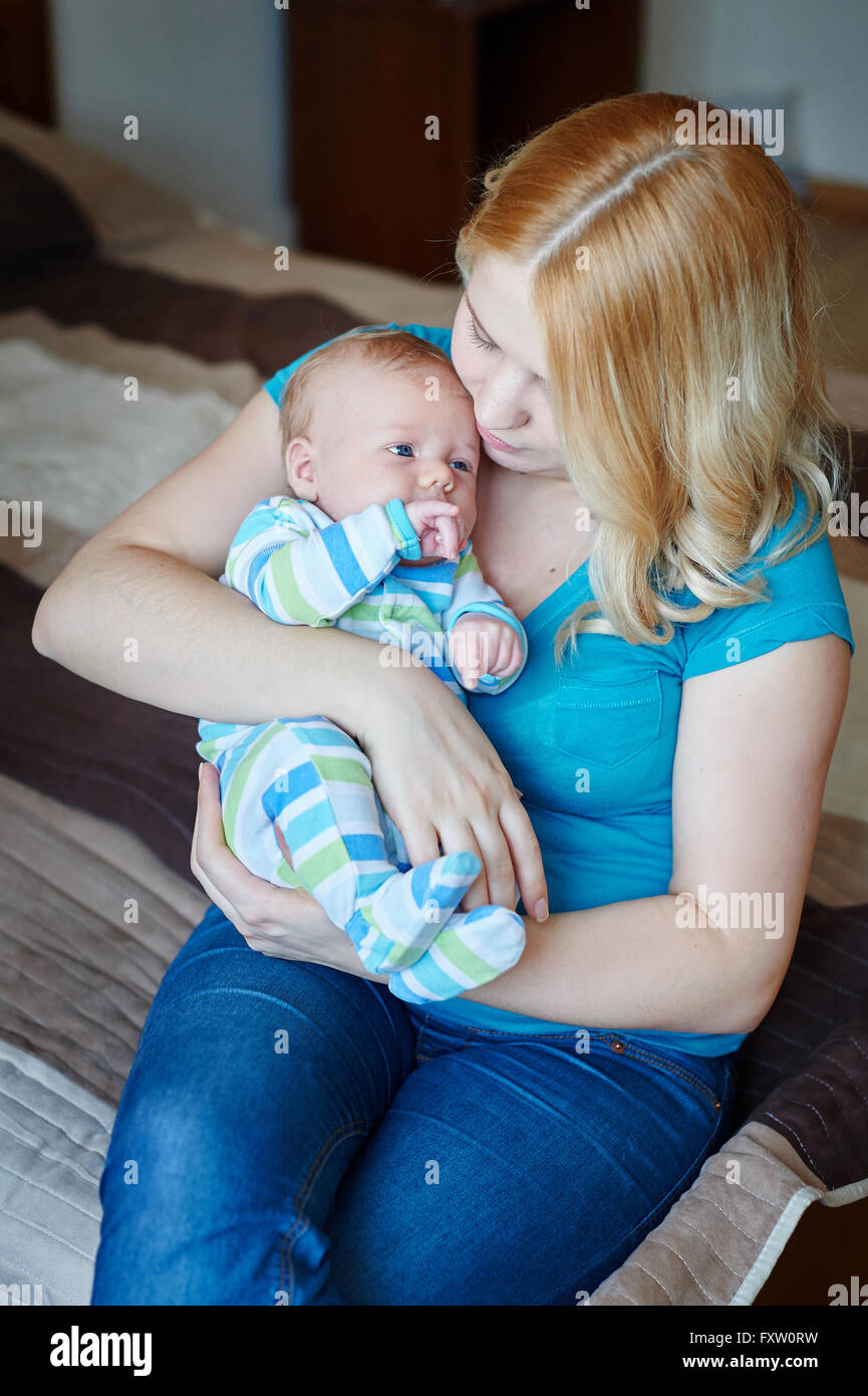 junge Mutter mit ihrem Baby Sohn in armen Stockfoto