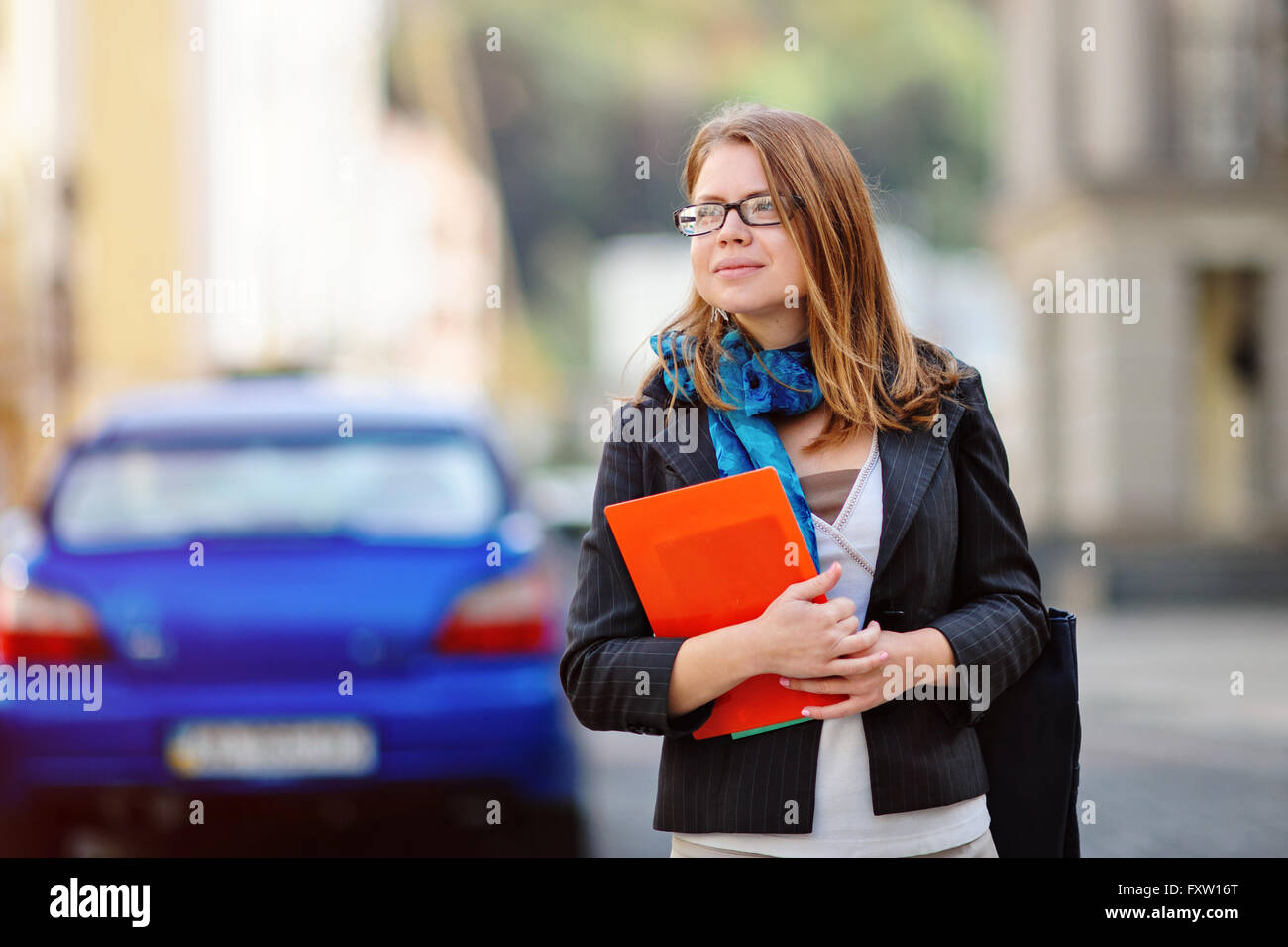 Porträt von glücklich lächelnde Geschäftsfrau mit roten Ordner in Stadt Stockfoto