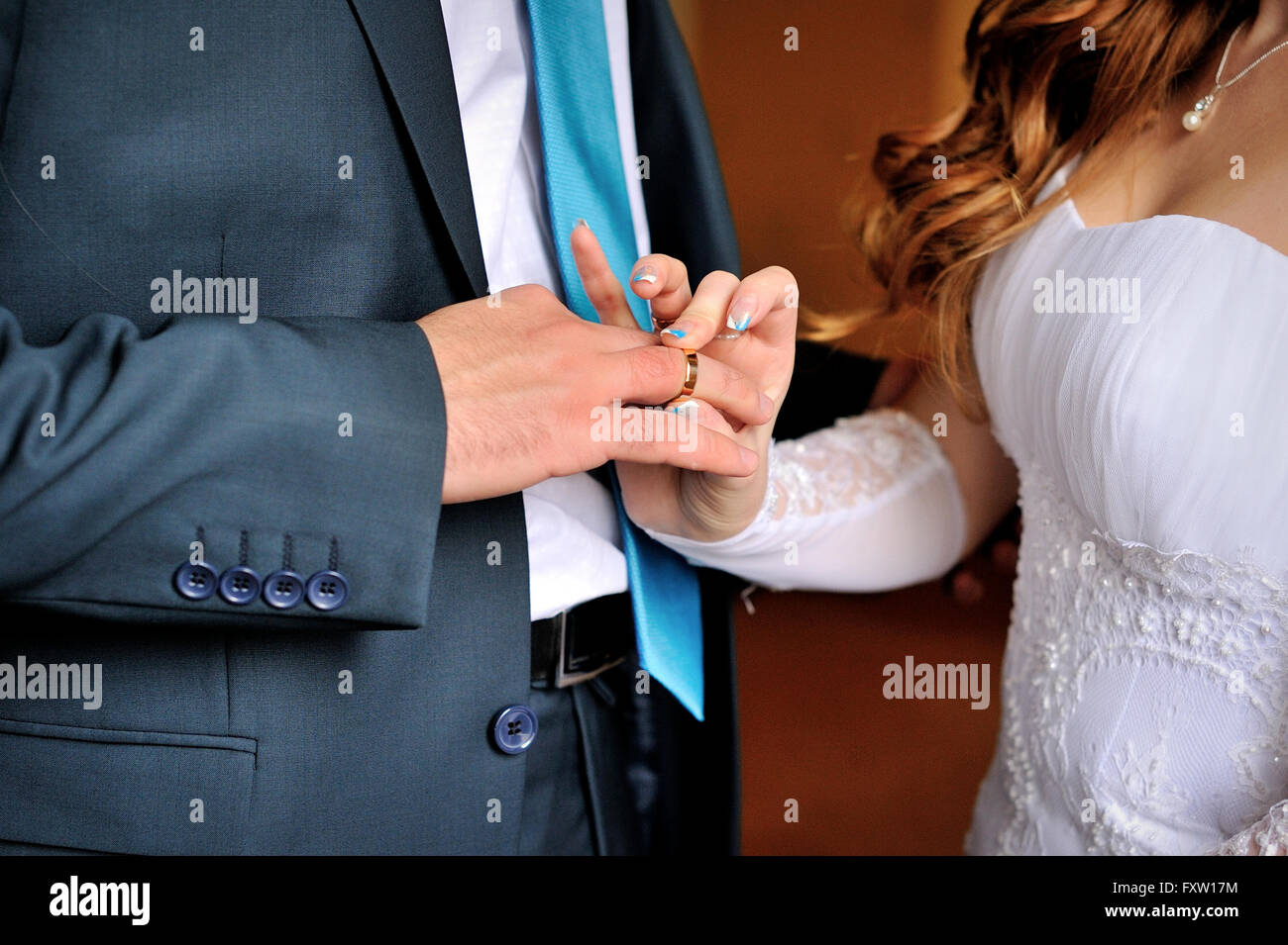 Braut trägt Bräutigam gold Ring auf Hochzeits-Zeremonie Stockfoto