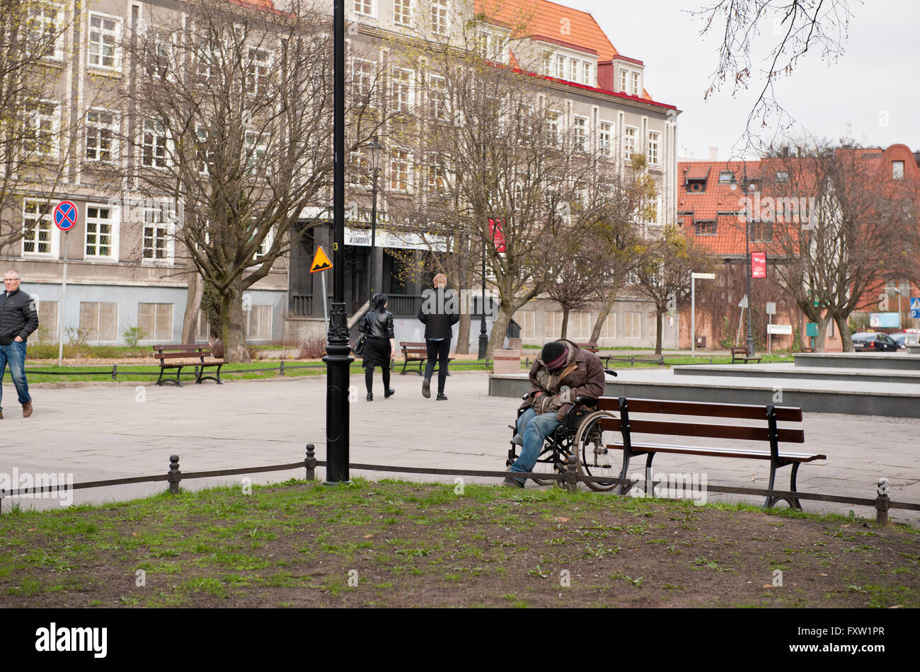 Buckliger ungültig Obdachloser am Rollstuhl, schlafen draußen im Park, kalten Frühlingstag in Danzig, Westpommern Stockfoto