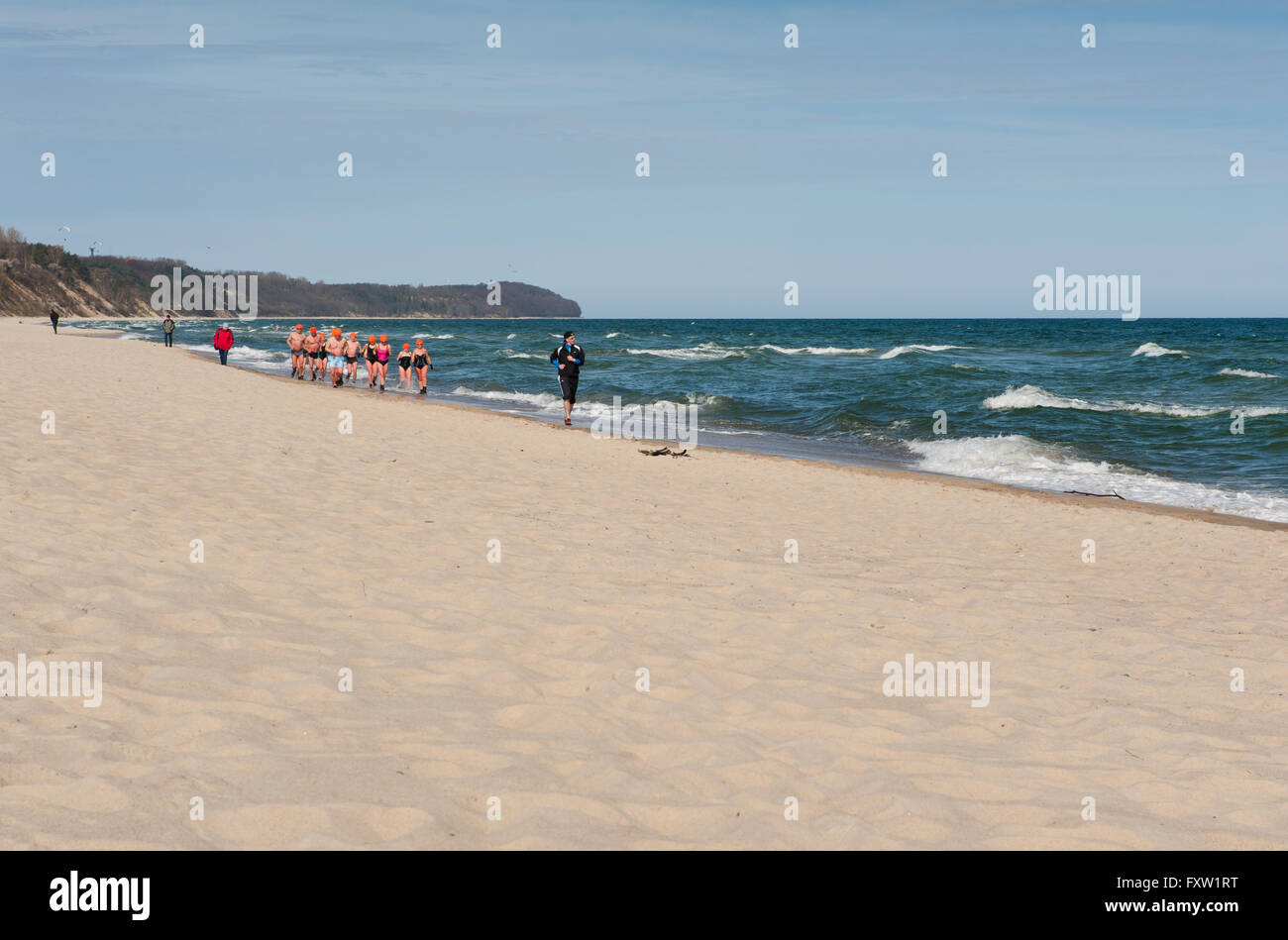 Winter-Schwimmer in Wladyslawowo Küste, Polen, Europa, Menschen laufen, aktiven Sport auf sandigen Ostseestrand Aufwärmen Stockfoto