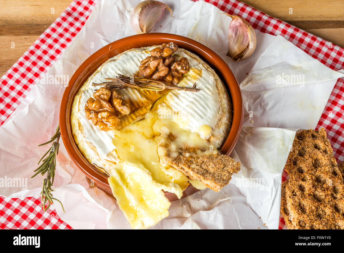 Gebackener Camembert Käse mit Honig, Knoblauch und Rosmarin Stockfoto