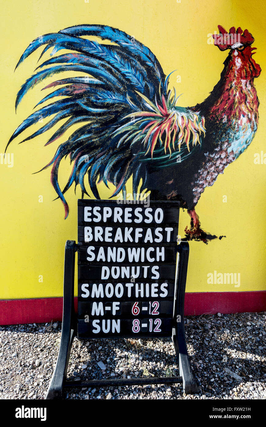 Sandwichbrett Schild und ein Gemälde von einem Hahn auf eine gelbe Wand ein Café an der Hauptstraße in Eureka, Nevada. Stockfoto