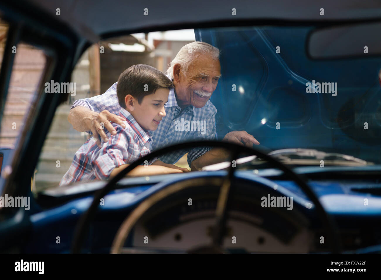 Familie und die Kluft zwischen den Generationen. Alte Opa verbringen Zeit mit seinem Enkel. Der ältere Mann zeigt den Motor eines Oldtimers von th Stockfoto