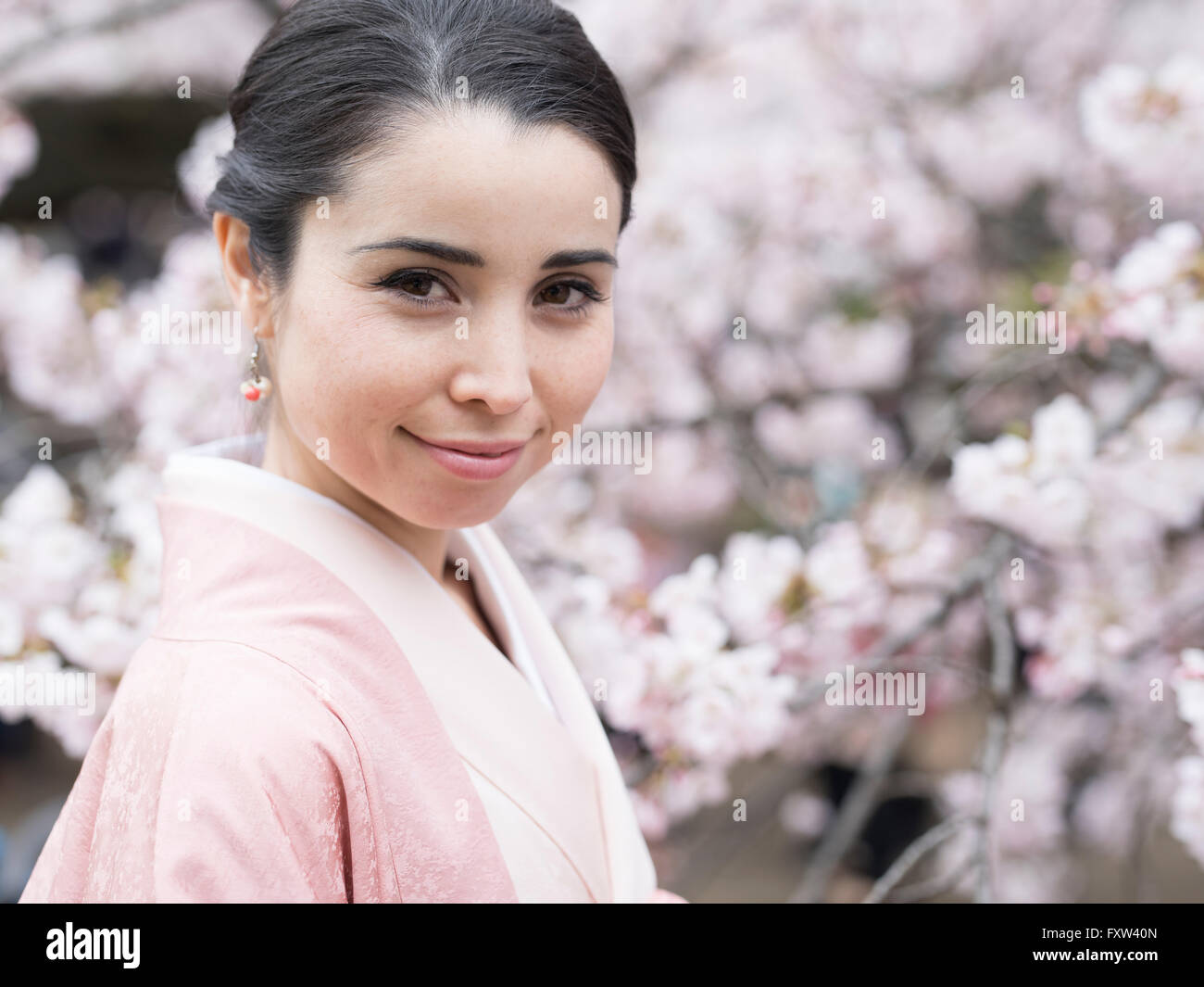 Porträt der jungen Japanerin tragen Kimono mit Kirschblüten in Shinjuku Gyōen Park, Tokio, Japan, Stockfoto