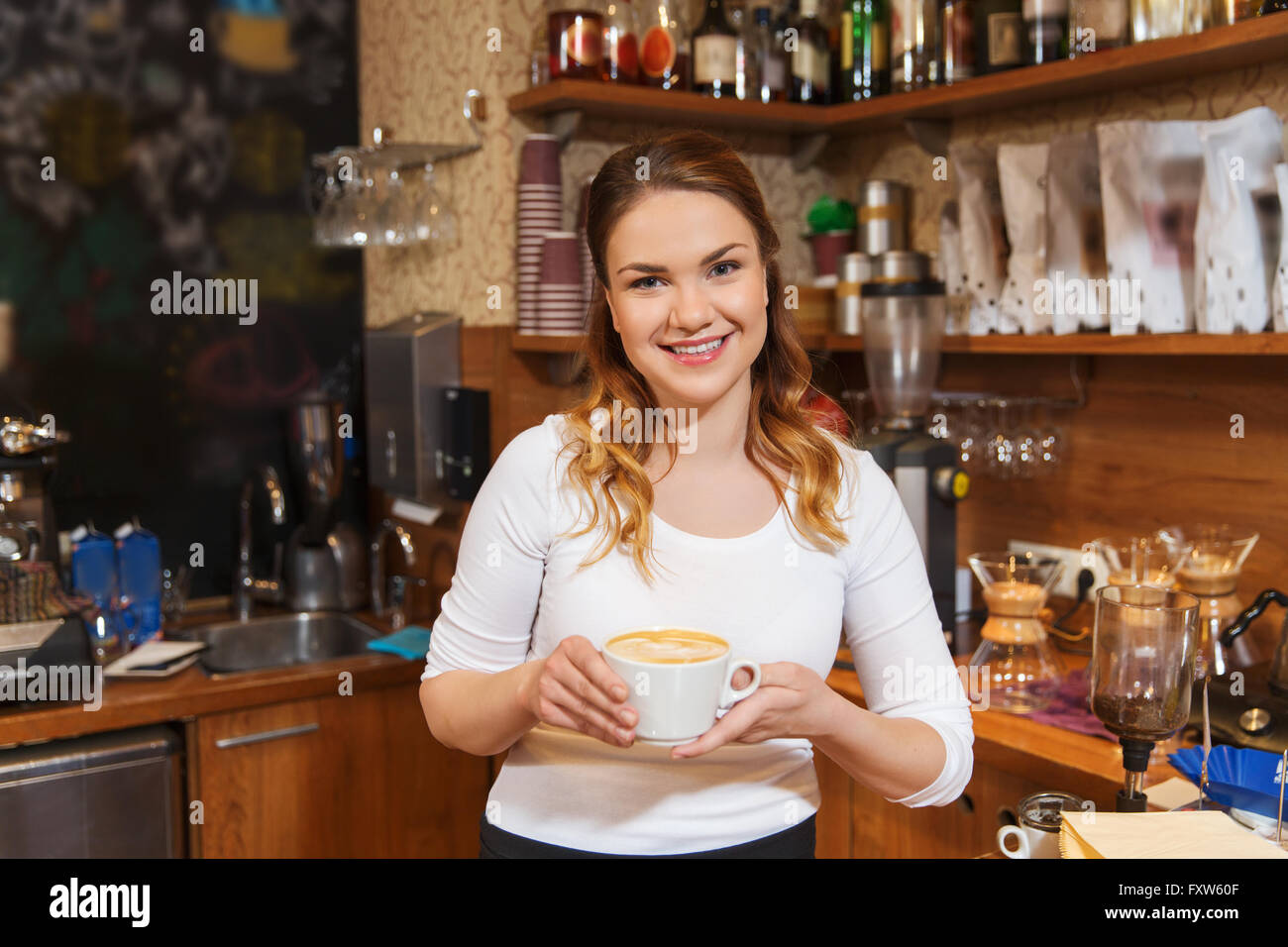 Frau glücklich Barista Latte im Kaffee-shop Stockfoto