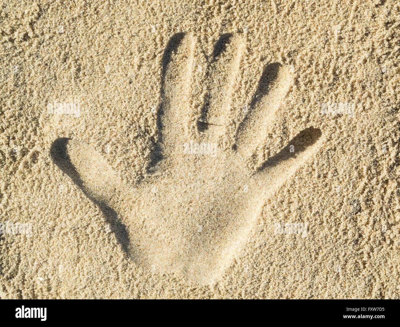 Optische Täuschung - Handabdruck in sand Stockfoto
