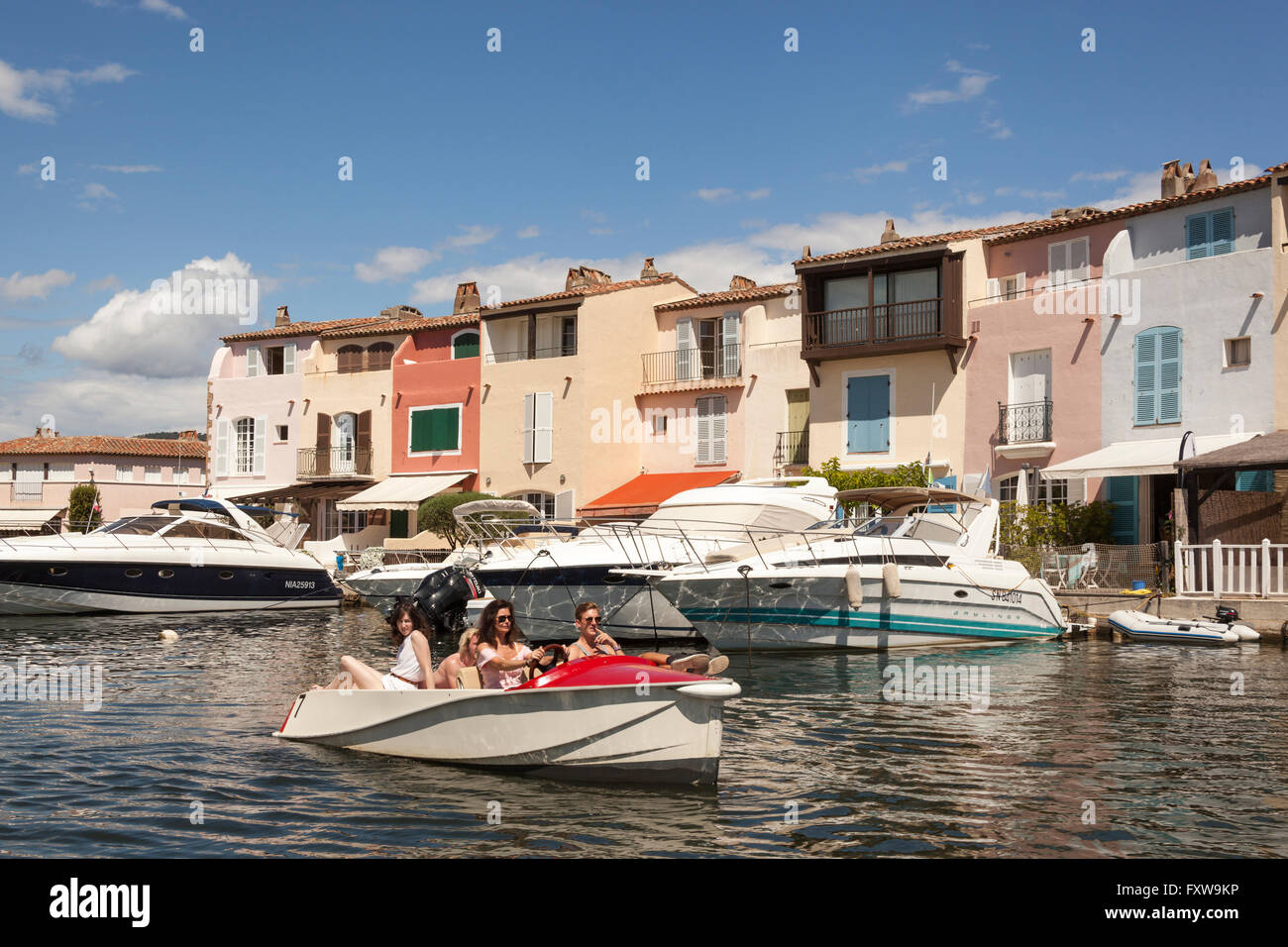 Touristen in einem Boot vorbei am Wasser Häuser, Port Grimaud, Cote d ' Azur, Frankreich Stockfoto